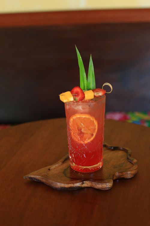 Free Colorful fruit cocktail with citrus and pineapple on a handcrafted wooden tray in Hội An, Vietnam. Stock Photo