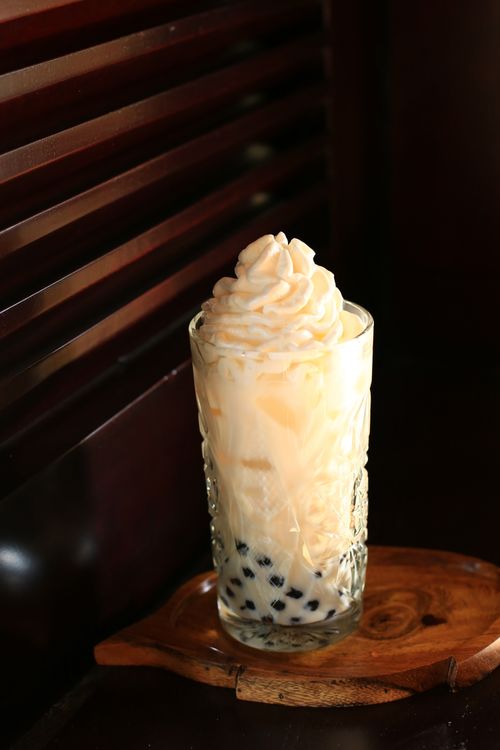 Free Iced bubble tea with whipped cream served in an elegant glass, captured in Hội An, Vietnam. Stock Photo