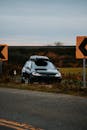Black Car on Rural Road with Directional Signs