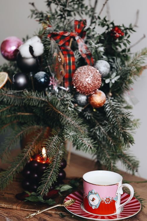 Free Cozy scene featuring Christmas decorations and a festive tea cup. Stock Photo