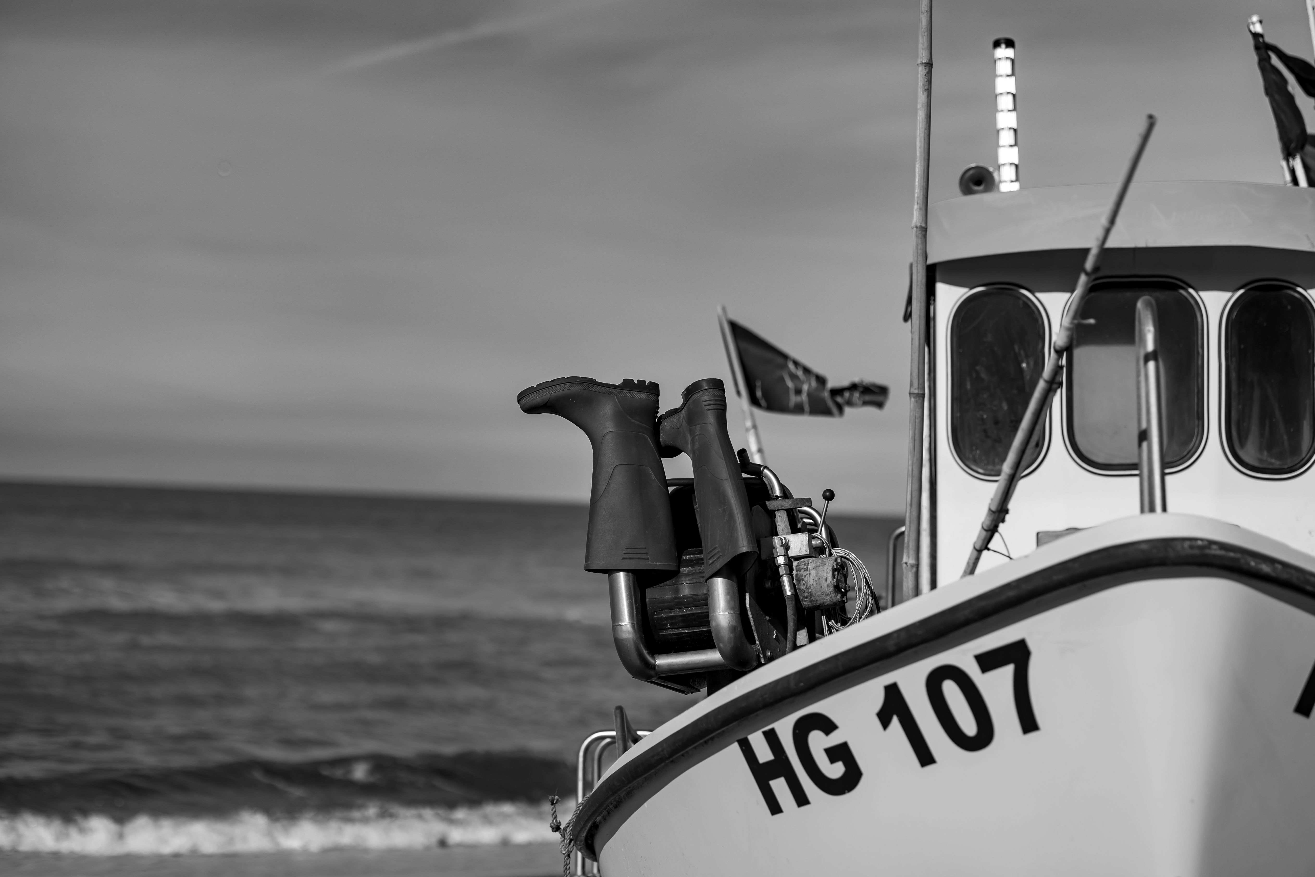 Monochrome image of a fishing boat with rubber boots on the deck in Lønstrup, Denmark.