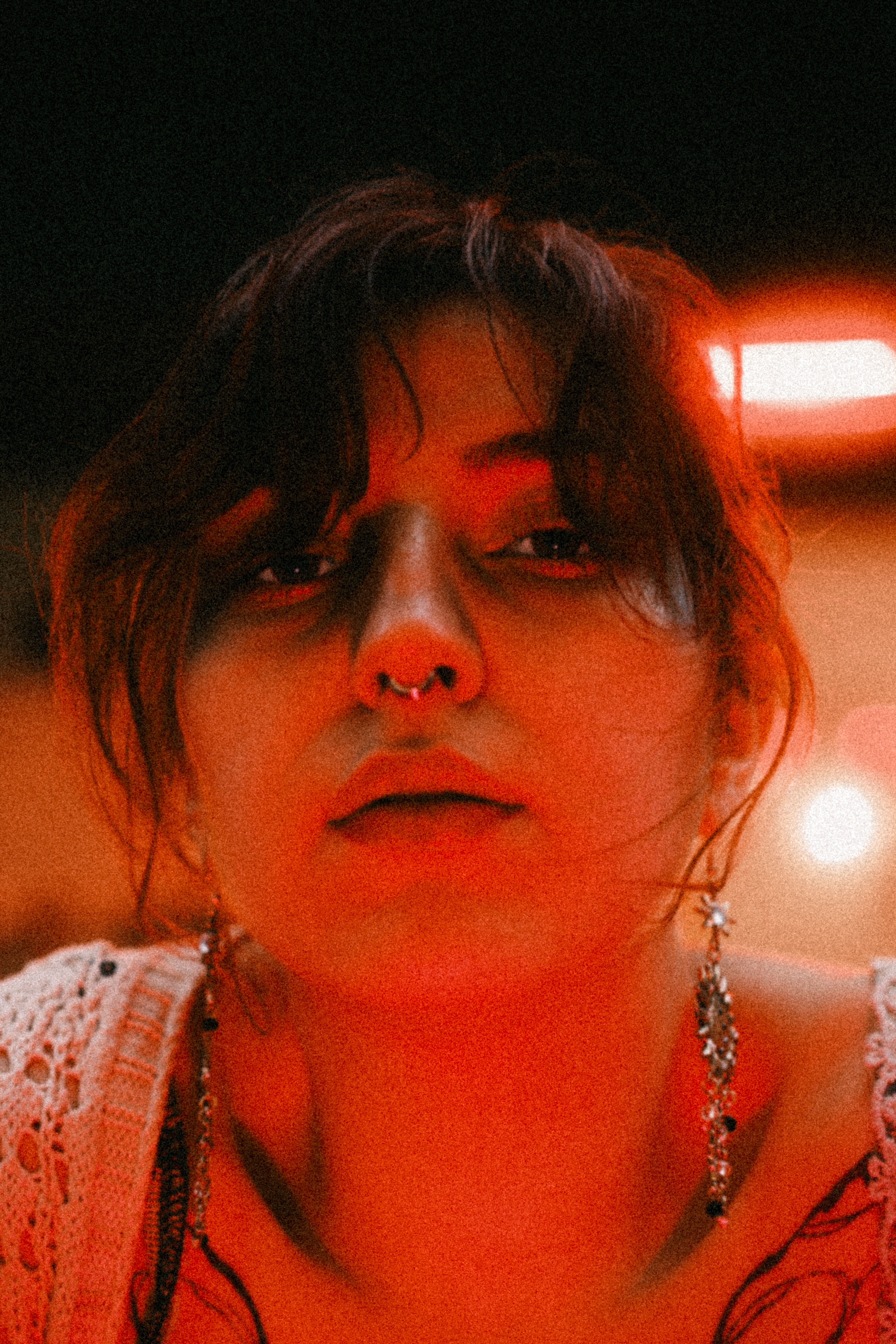 Dramatic portrait of a young woman with neon lighting, showcasing a thoughtful expression.