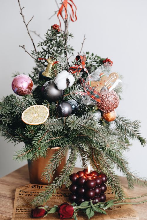 Free Elegant Christmas arrangement with ornaments and candle, ideal for holiday settings. Stock Photo