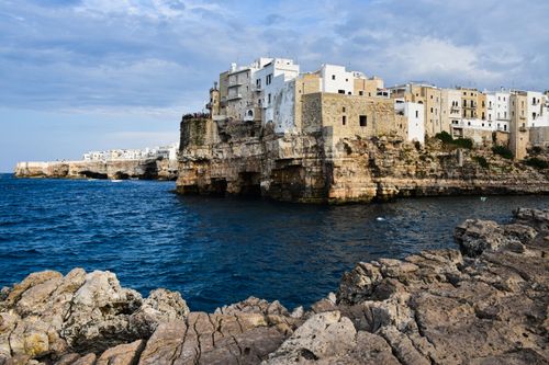Free Scenic view of Polignano a Mare's historic architecture atop rocky cliffs by the sea. Stock Photo