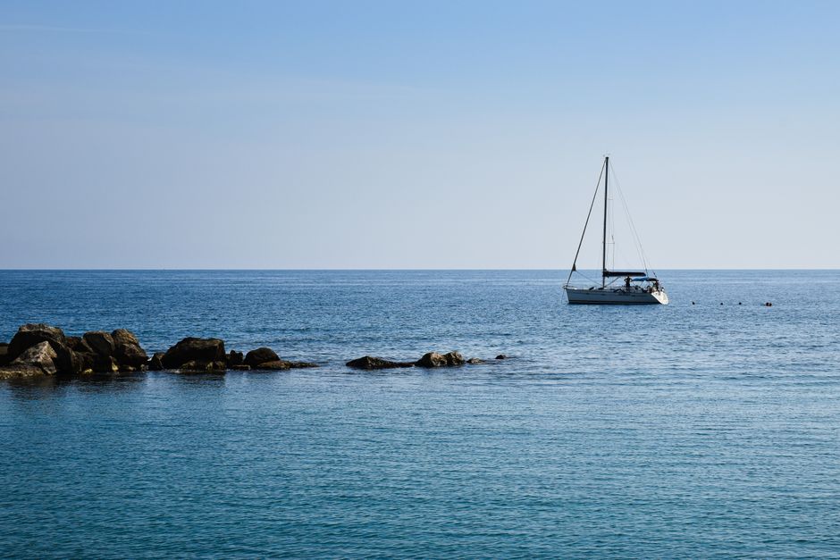 Incredible Private Amalfi Coast Boat Trip from Positano, Praiano or Amalfi Review: The Ultimate Italian Coastal Experience Review 2026 - Tranquil scene of a yacht sailing on the clear blue sea near rocky shores in Apulia, Italy.