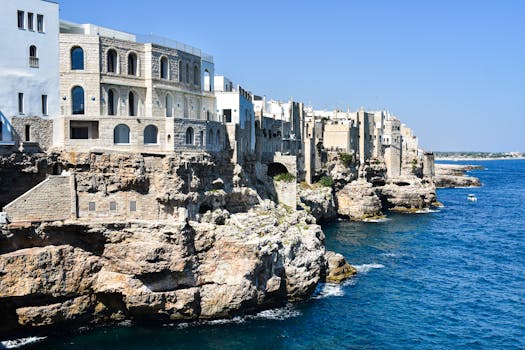 Vista mozzafiato sulle scogliere storiche di Polignano a Mare e sul mare azzurro della Puglia, Italia.