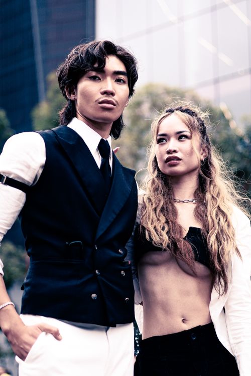 Free Elegant couple posing outdoors in Darling Harbour, showcasing a modern fashion look. Stock Photo