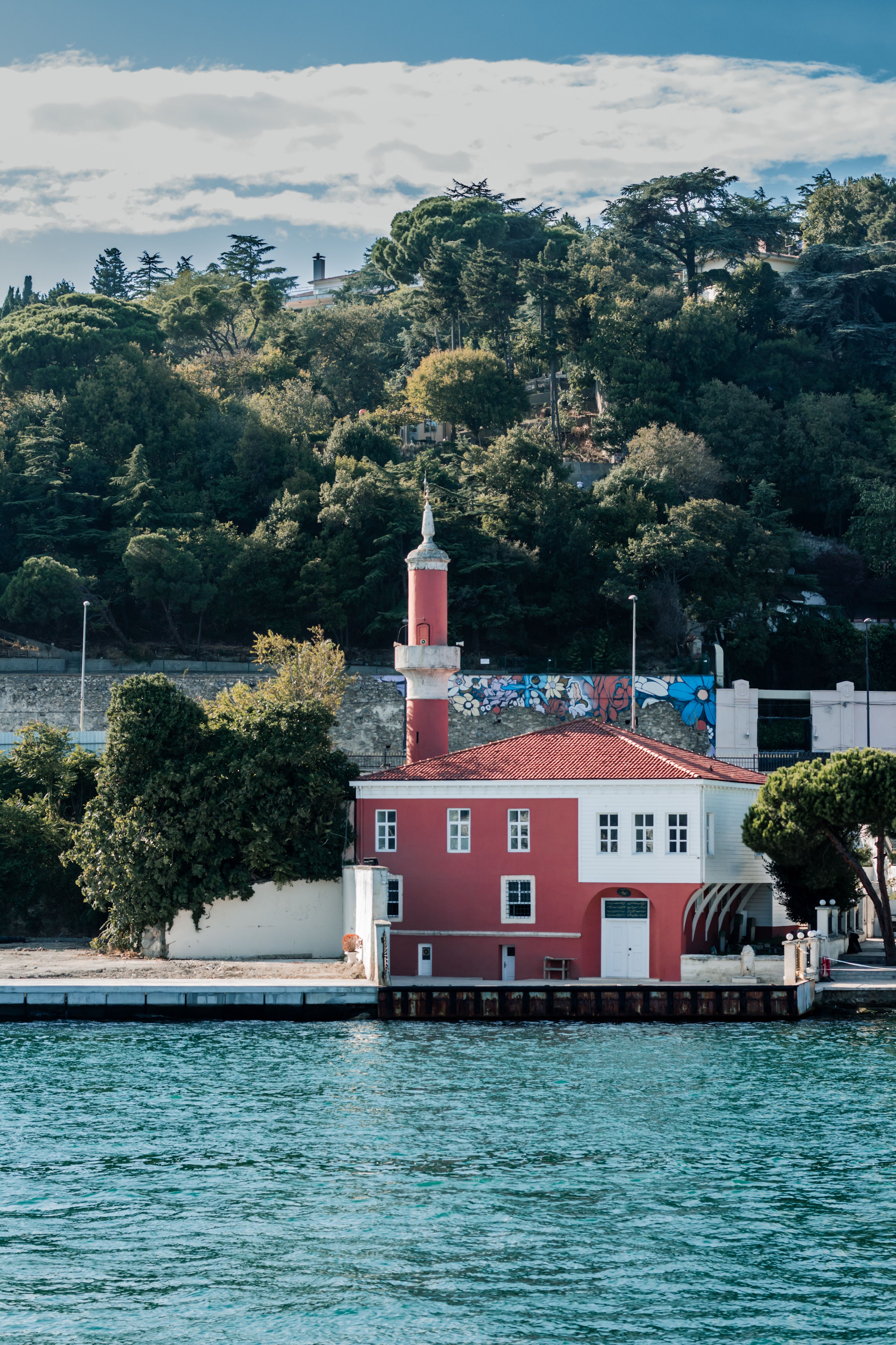 Picturesque Red Building by a Serene Waterfront · Free Stock Photo