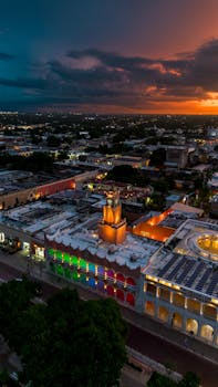 Aerial view of colorful colonial buildings in Mérida at sunset, showcasing vibrant architecture.