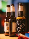 Three beer bottles with a sports-themed cozy