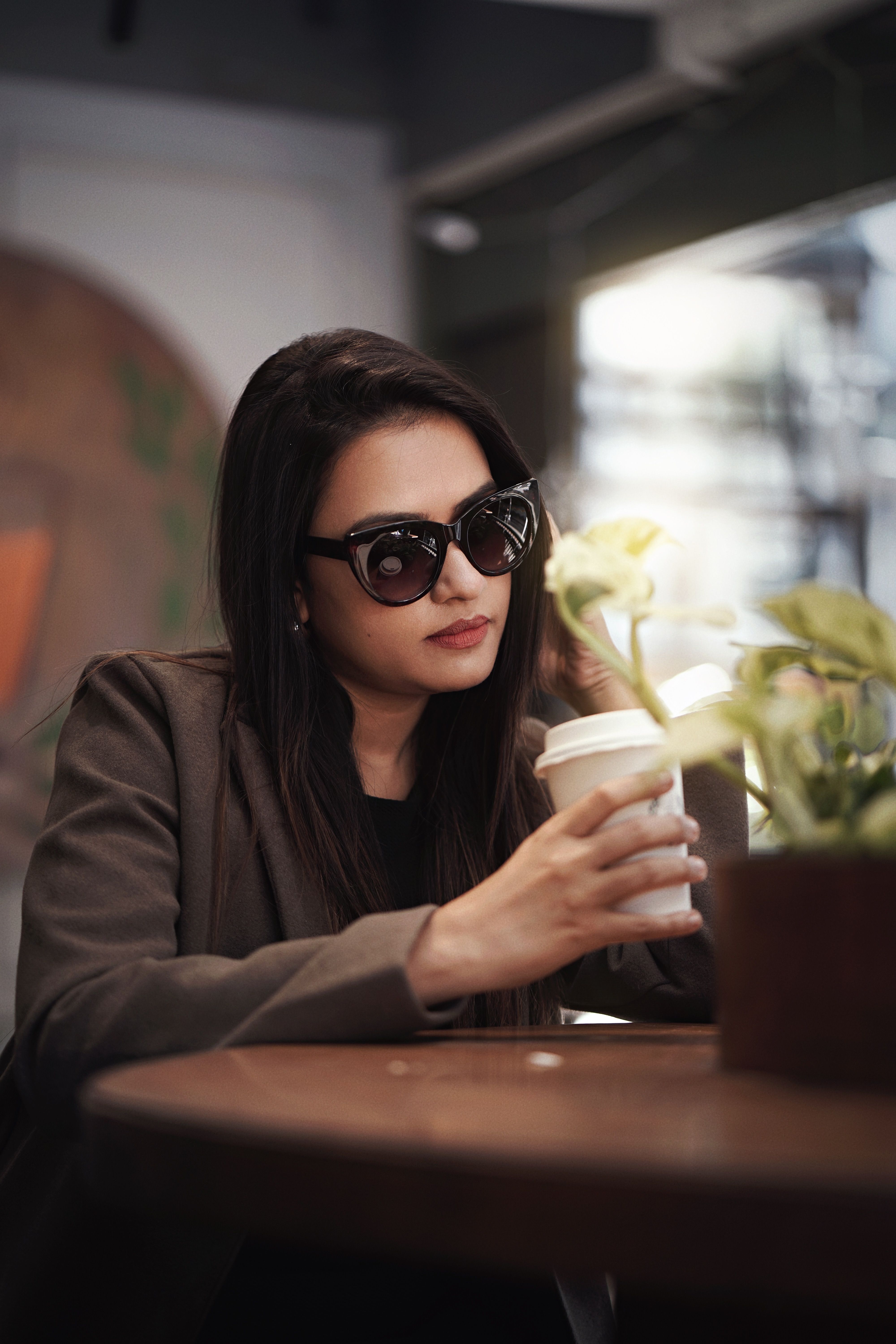 Woman in Café Holding Coffee Cup · Free Stock Photo