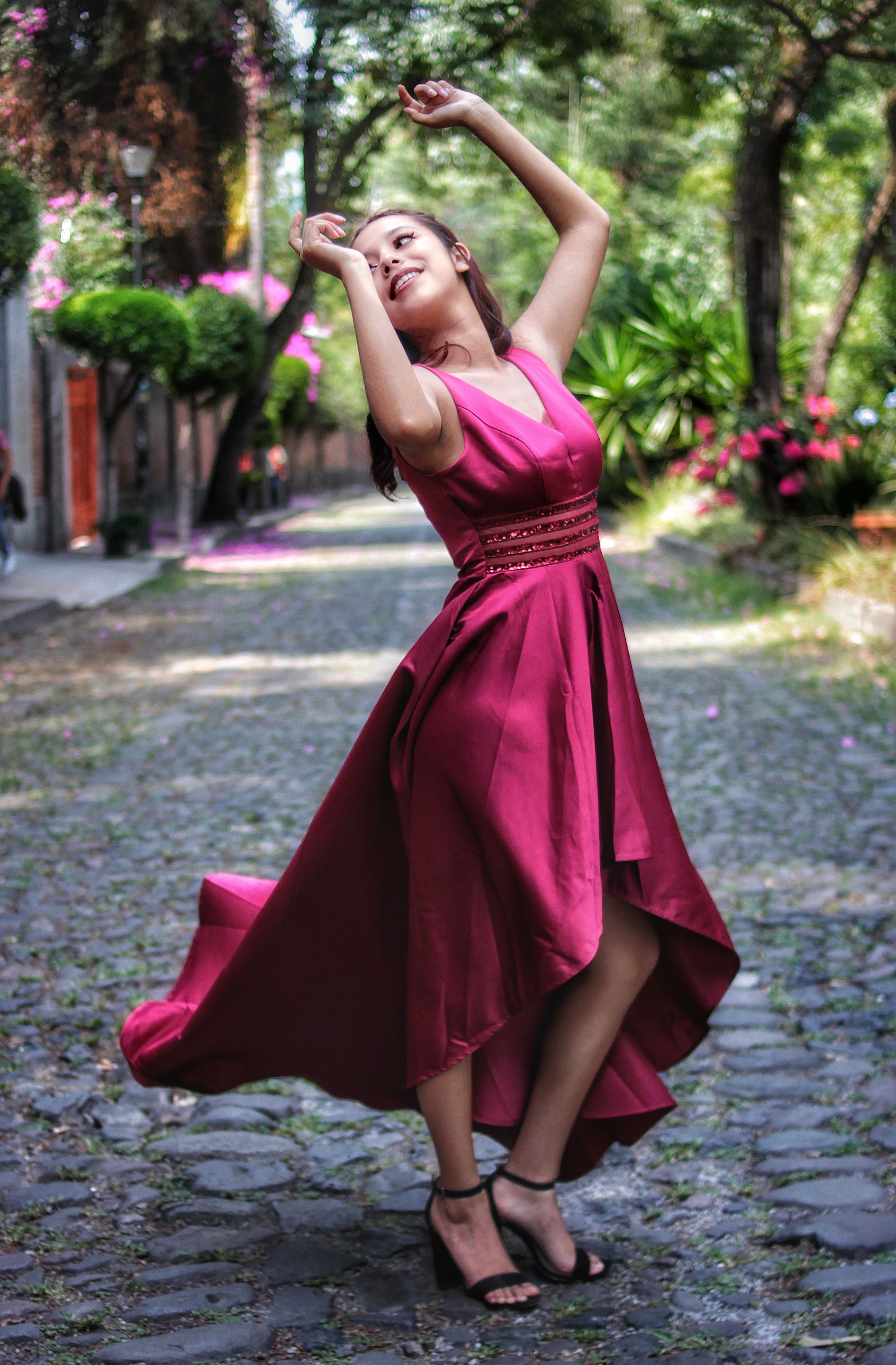 Elegant Woman Dancing on Cobblestone Street · Free Stock Photo