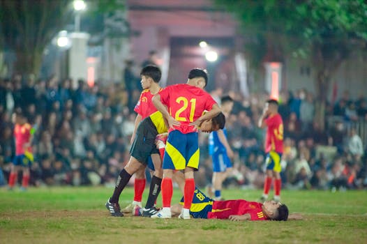 Intense soccer match in Hanoi, capturing players in action at night.