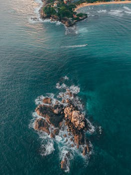 Stunning aerial shot of the rocky coastline and blue ocean near Sri Lanka, showcasing natural beauty.