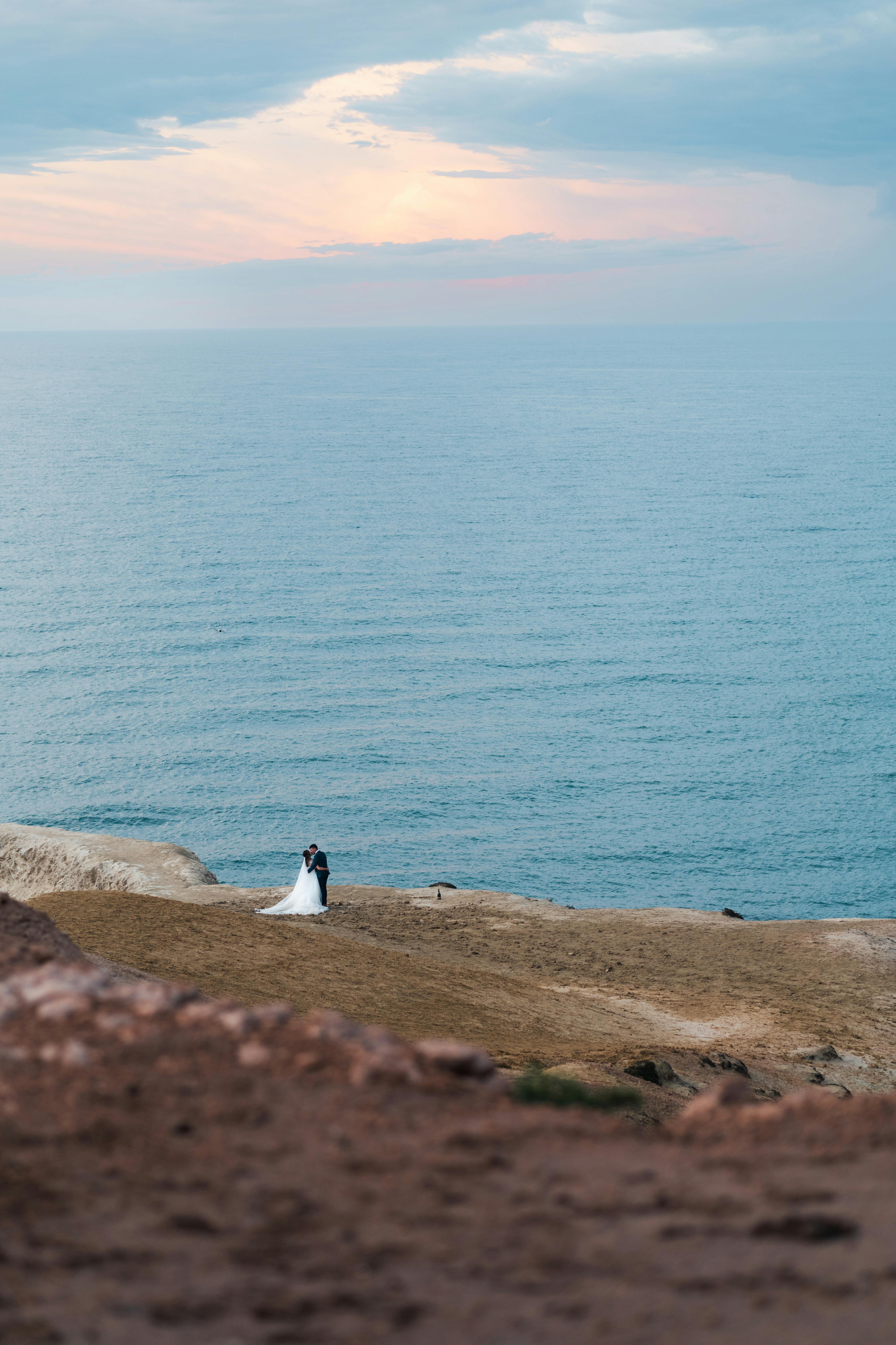 A couple embraces by the sea at sunset on the serene cliffs of Port Willunga, Australia.