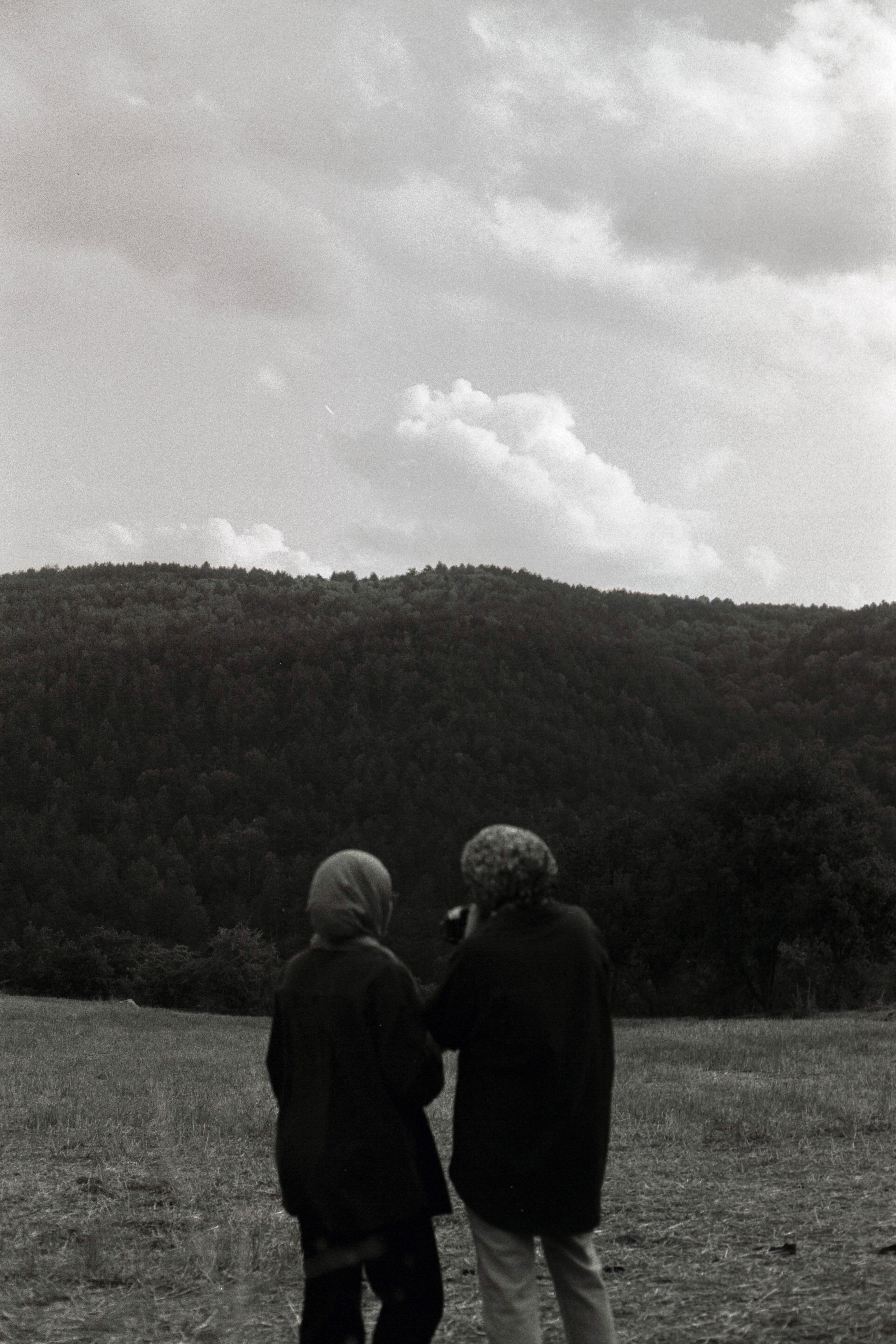 Black and White Landscape with Two People Observing · Free Stock Photo