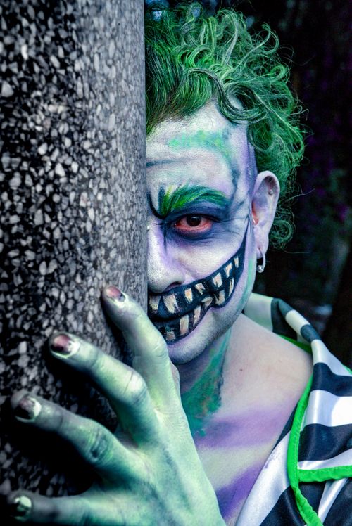 Free A striking portrait of an adult with vivid face paint and theatrical costume, creating a dramatic and artistic impression. Stock Photo