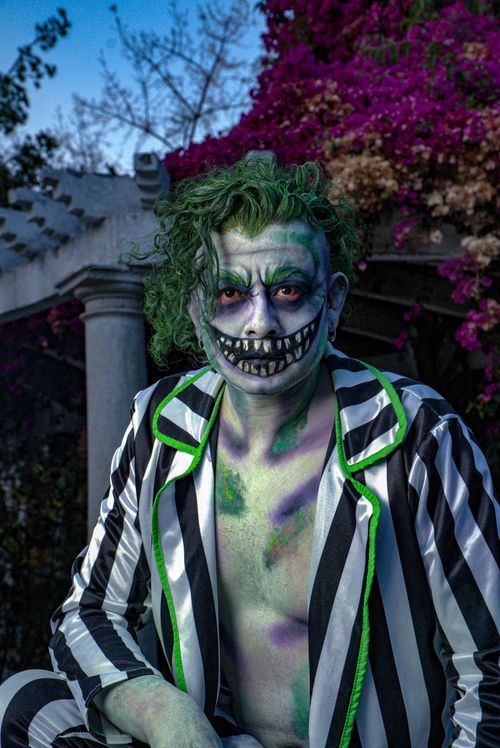 Free A striking portrait capturing a person in vibrant striped costume and makeup outdoors. Stock Photo