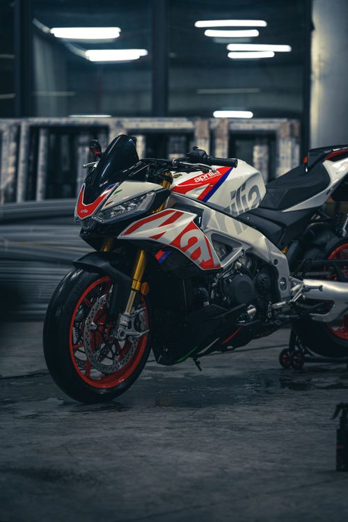 Free Aprilia motorcycle in urban garage, showcasing sporty design and vibrant colors. Stock Photo