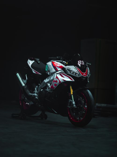 Free High-performance motorcycle with striking decals parked in a dim, atmospheric setting. Stock Photo