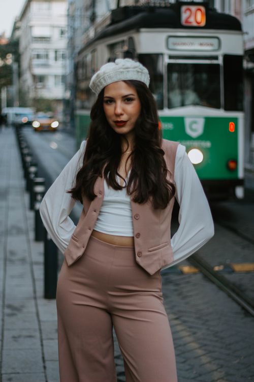 Free Chic woman in trendy outfit poses confidently in front of a classic Istanbul tram. Stock Photo