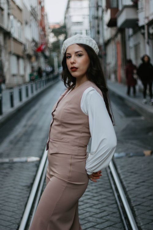 Free Stylish woman in chic outfit posing on a tramway-lined street in Istanbul. Stock Photo