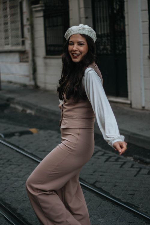 Free Stylish woman in fashionable attire smiling on a historic street in İstanbul, Türkiye. Stock Photo