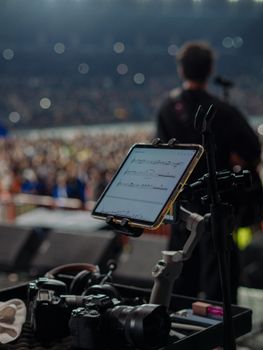 A musician performing on stage with professional photography and music equipment in view.