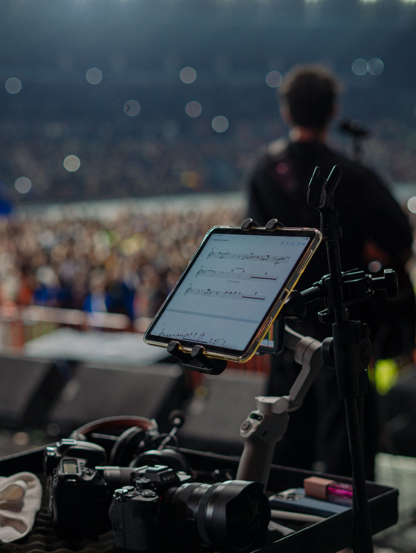 Musician performing on stage with digital equipment used to manage show information and song lists