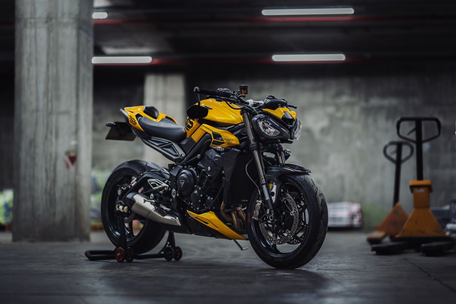 Stylish yellow motorcycle parked in a dimly lit urban garage, showcasing modern design.