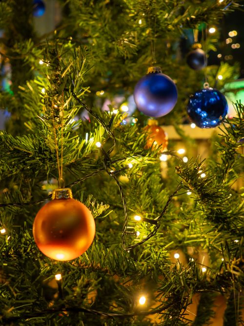 Free Close-up of a Christmas tree adorned with colorful baubles and lights, enhancing festive cheer. Stock Photo
