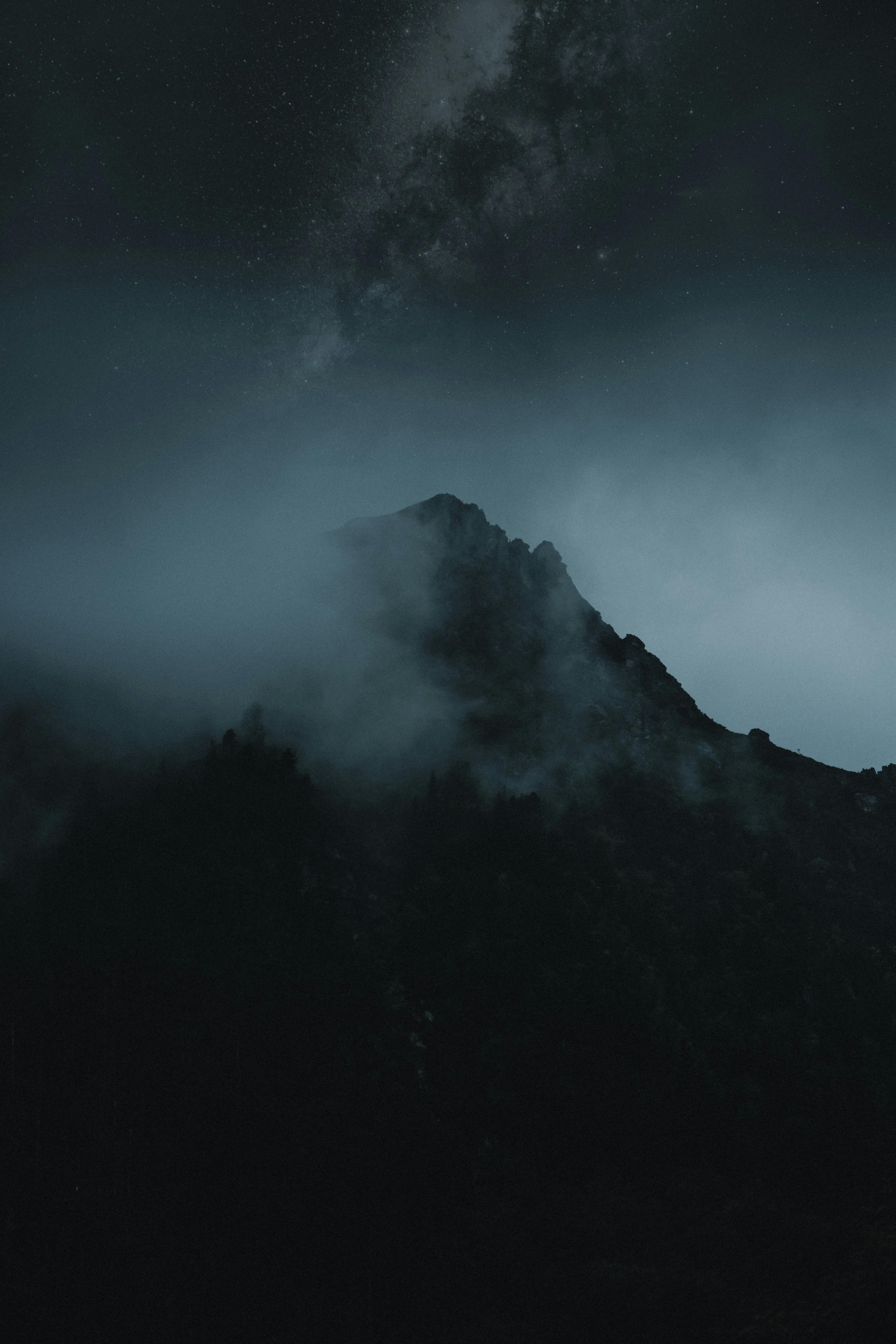 Dramatic night view of misty High Tatras mountains with the Milky Way in Slovakia.