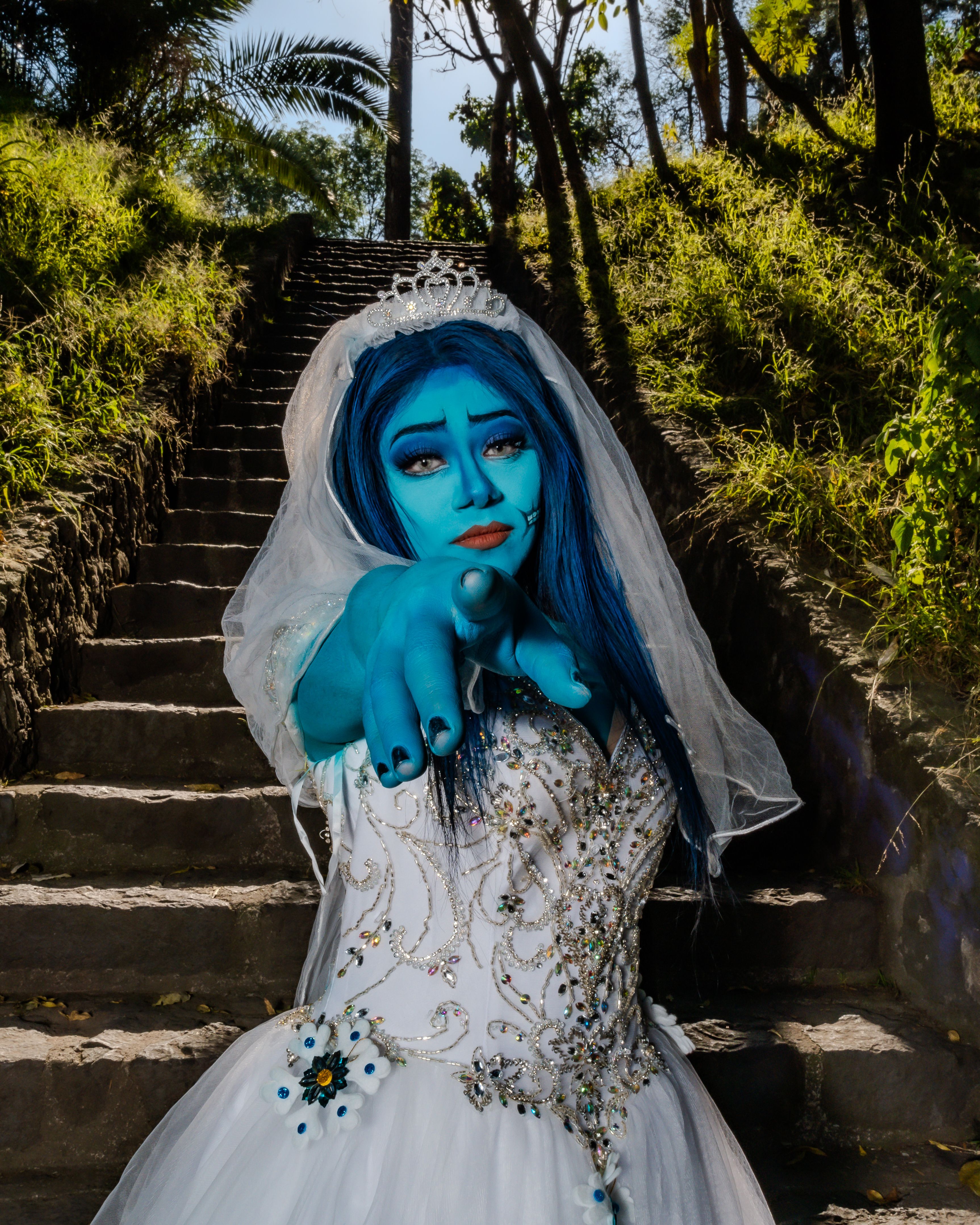 A fantasy-inspired portrait with a surreal blue-hued bride in a stunning outdoor setting.