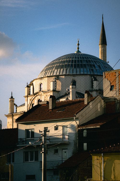 Free A historic dome and minaret in a cozy urban neighborhood at sunset. Stock Photo