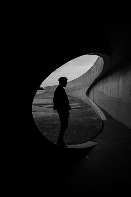 Monochrome silhouette of a man in abstract curved architectural setting, Belgium.