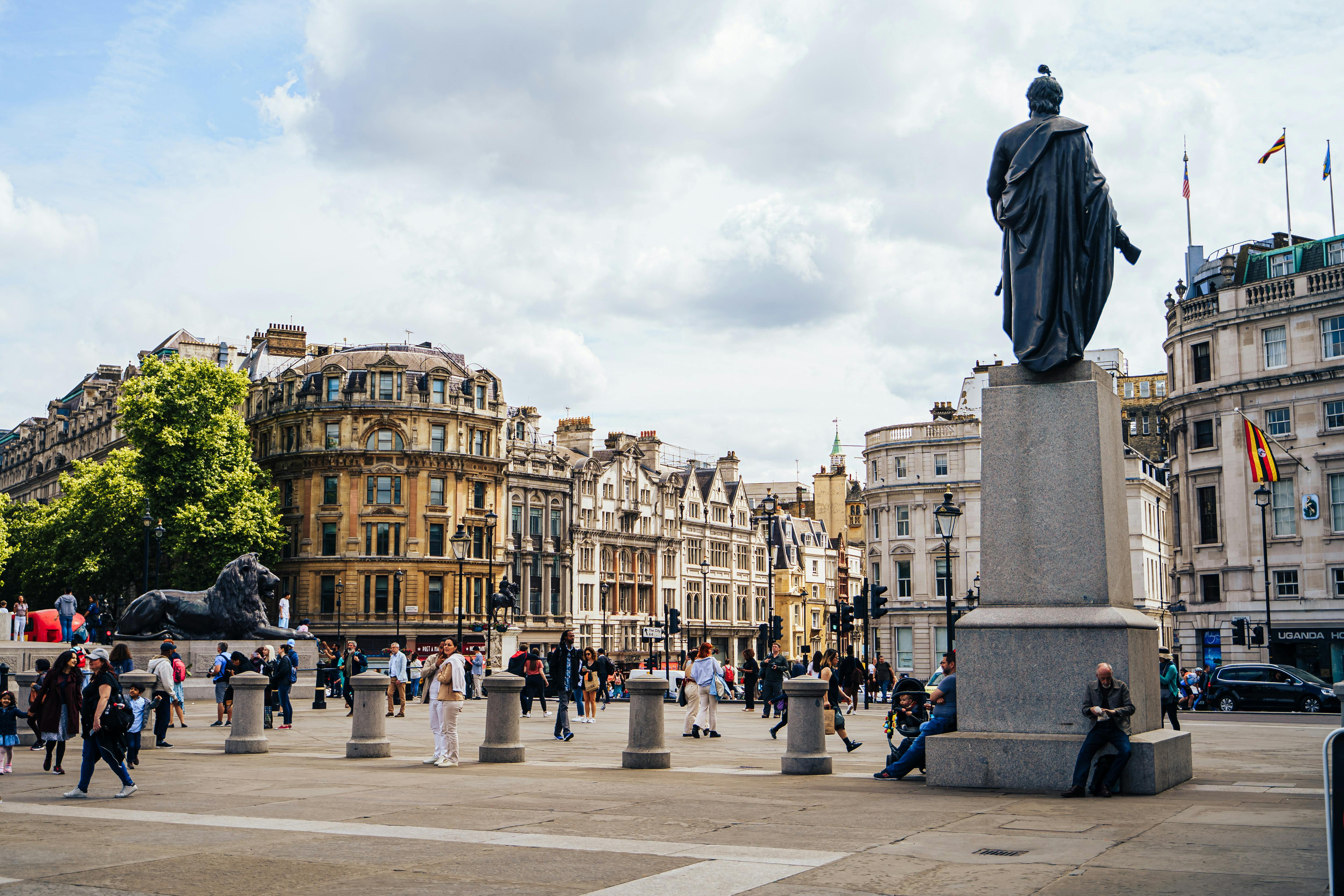 Vibrant scene of Trafalgar Square in London with historic architecture and lively crowd.