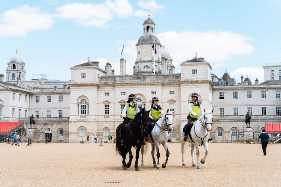 Mounted police patrol outside historic Horse Guards building in London.