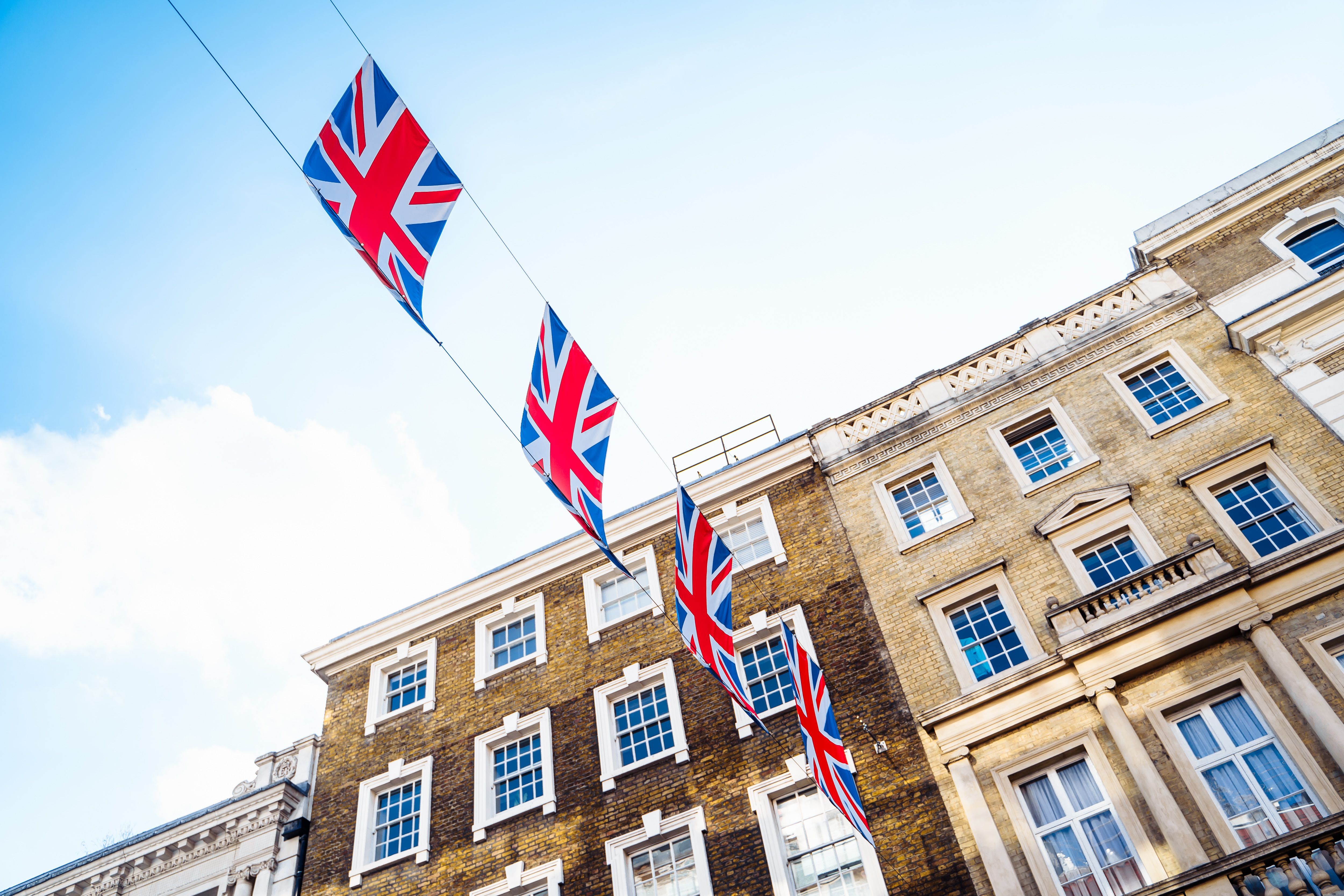 Historic London street adorned with Union Jack flags, celebrating UK culture and architecture.