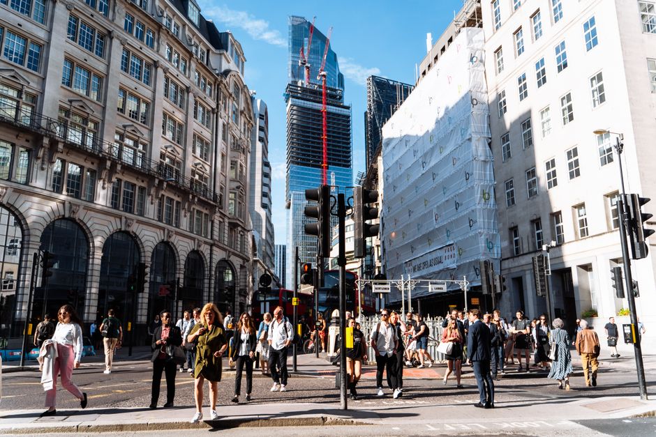 Busy London intersection showcasing historic and modern architecture with lively street life.