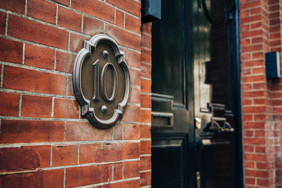 Close-up of a historic London brick facade featuring the iconic number 10 plaque.