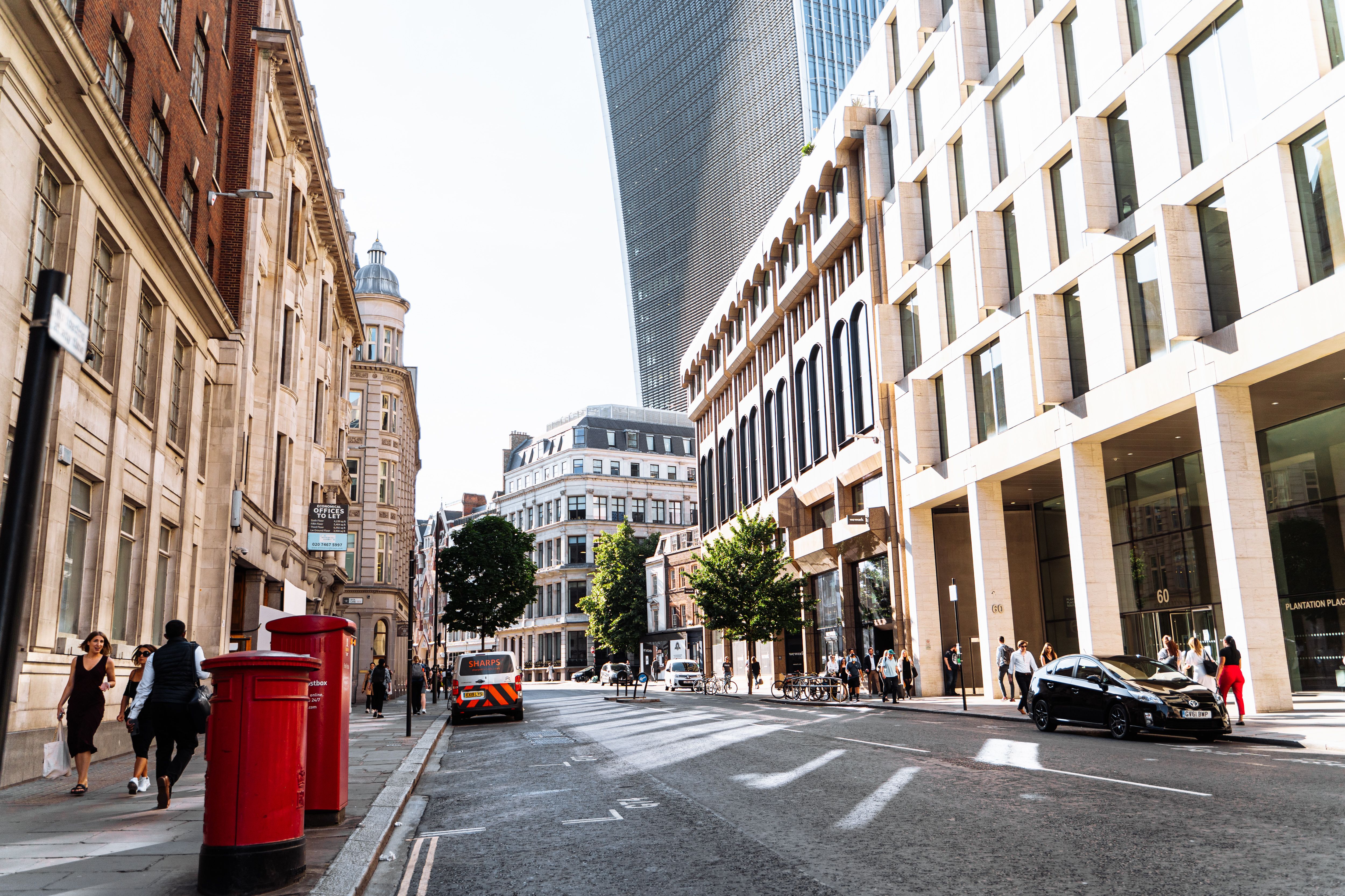 A vibrant London street showcasing historic and modern architecture in summer.
