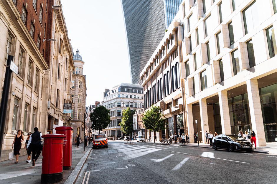 A vibrant London street showcasing historic and modern architecture in summer.