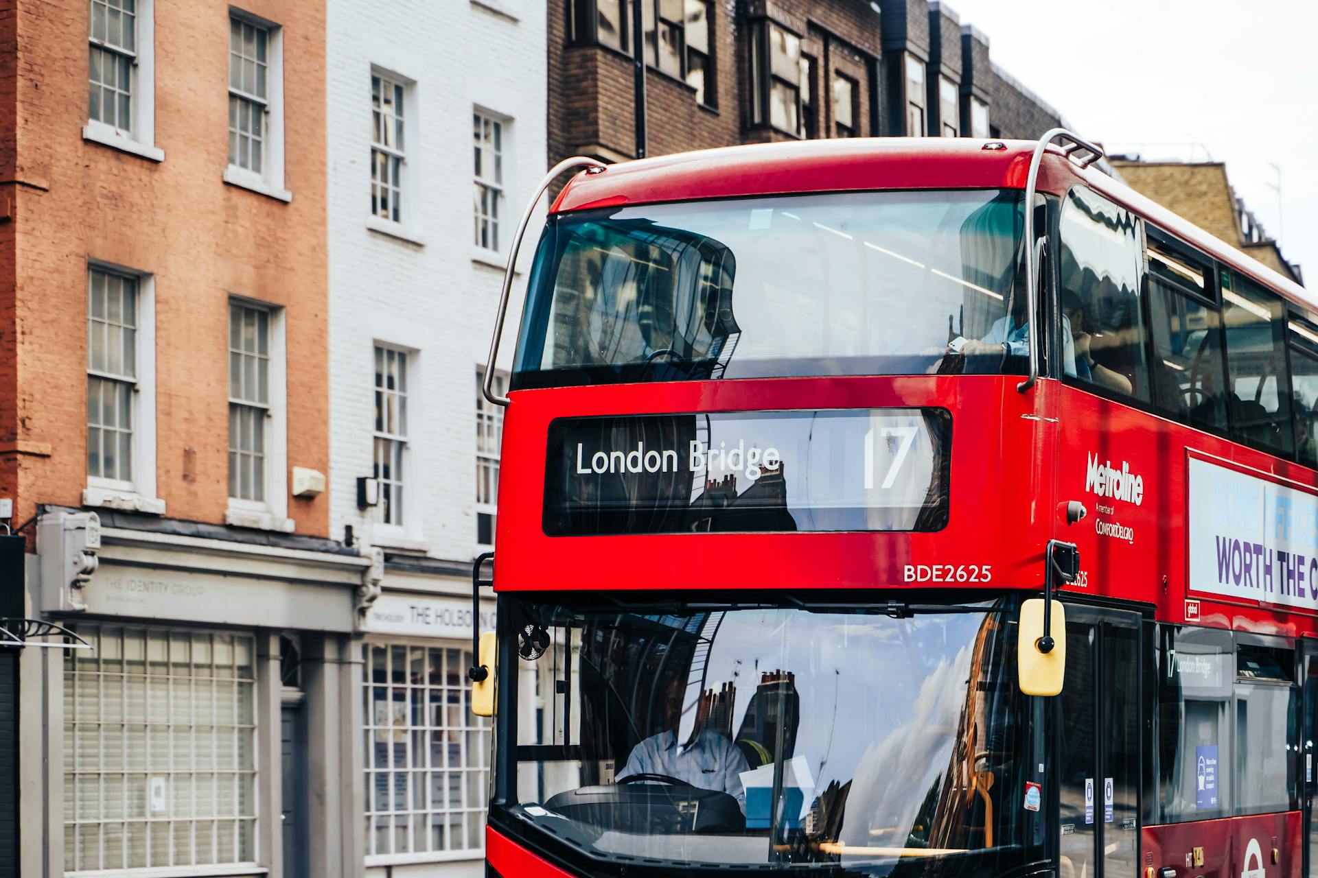 Red double-decker Metroline bus on route 17 at London Bridge, showcasing the city's urban architecture.