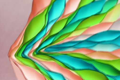 Free Vibrant layered paper art with green, blue, and peach colors in an abstract pattern. Stock Photo