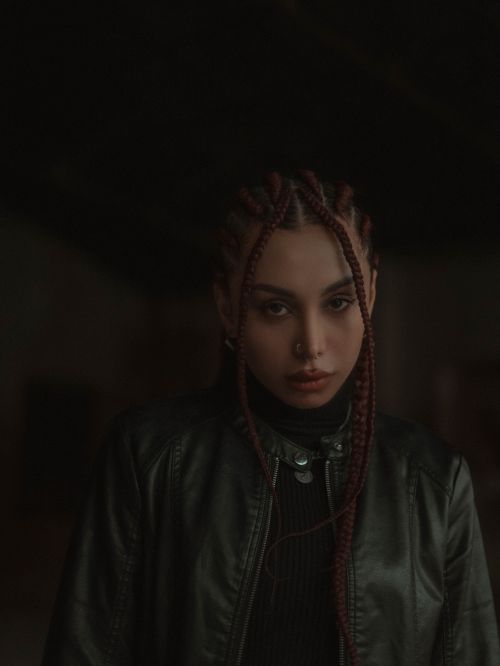 Free Dark and expressive portrait of woman with braided hair in a leather jacket. Stock Photo