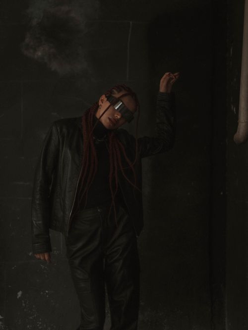 Free Stylish portrait of a person in dark attire with sunglasses in an indoor setting. Stock Photo