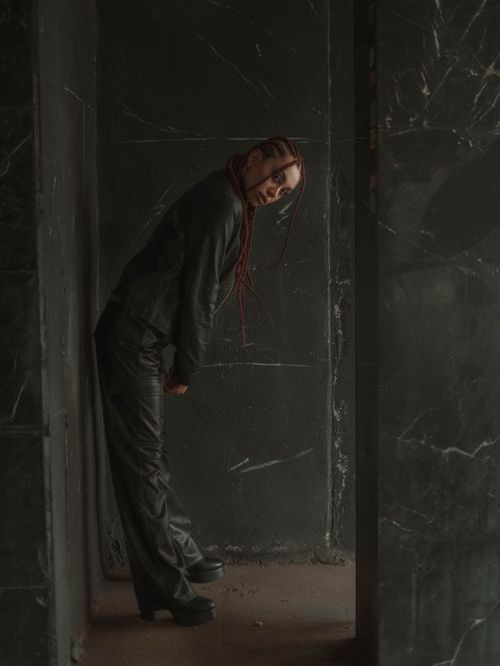 Free Woman in dark room wearing black outfit, creates a moody artistic vibe. Stock Photo