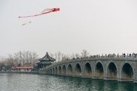 People On A Bridge Watching Kites Fly