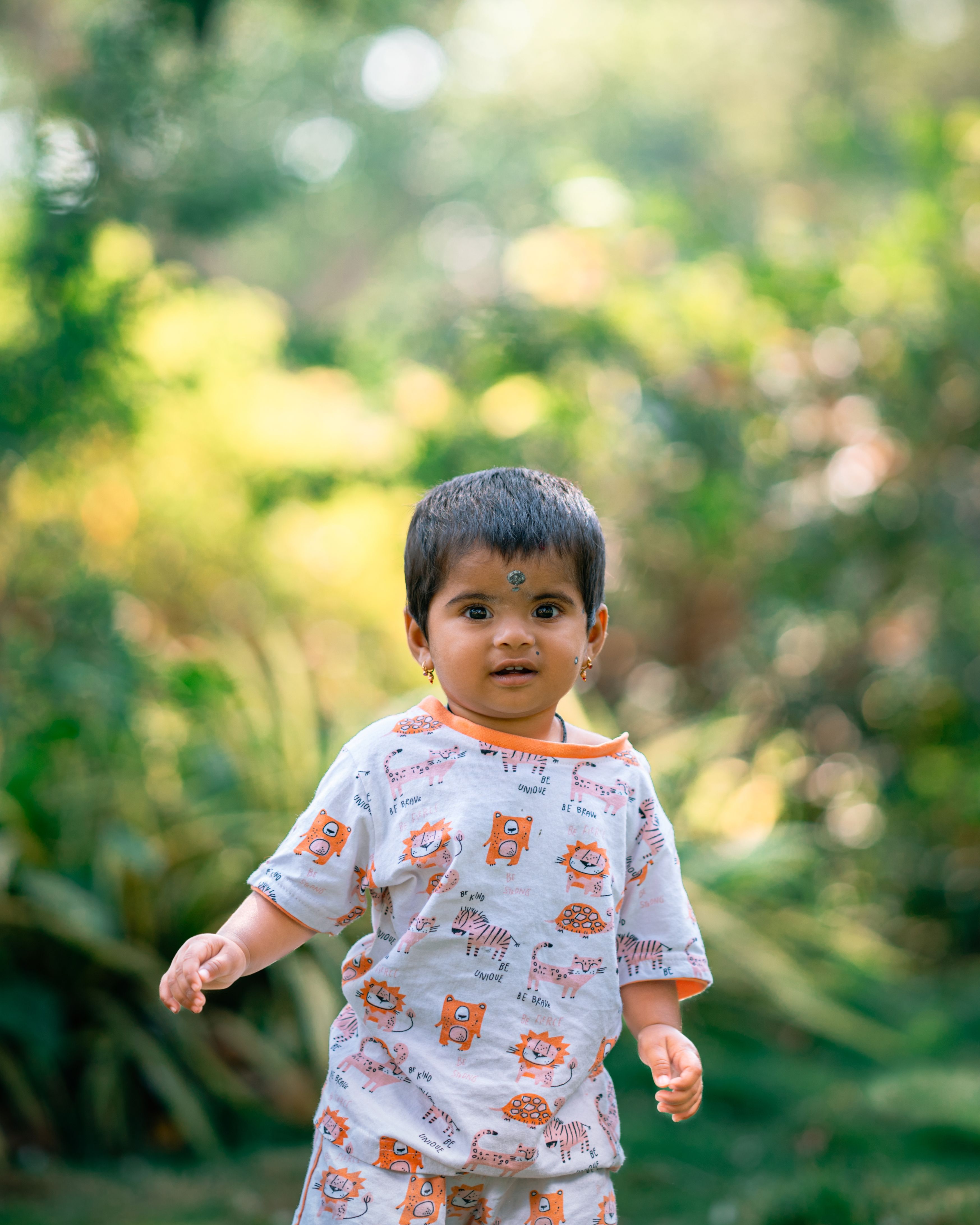 Charming toddler in printed attire exploring nature, capturing innocence and joy.