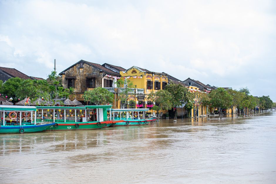 Serene riverside view of Hội An's charming historical architecture and colorful boats.